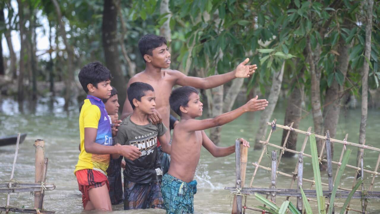 Locals wait to receives free food distributed by the Bangladesh Army, after a widespread flood in Sylhet district, in Bangladesh, 23 June 2022.