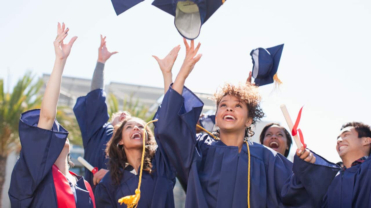 Graduates tossing caps into the air