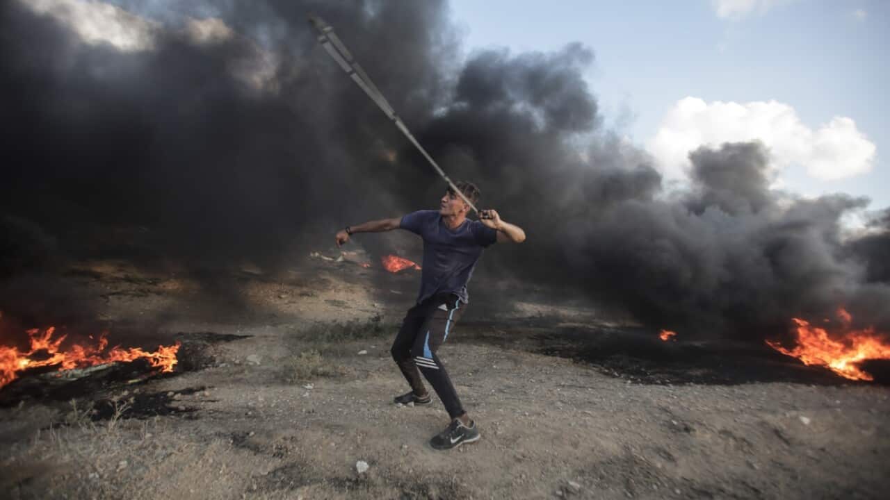 A Palestinian protester takes part during the clashes with Israeli troops near the border with Israel in the east of Gaza City on, 20 July 2018.