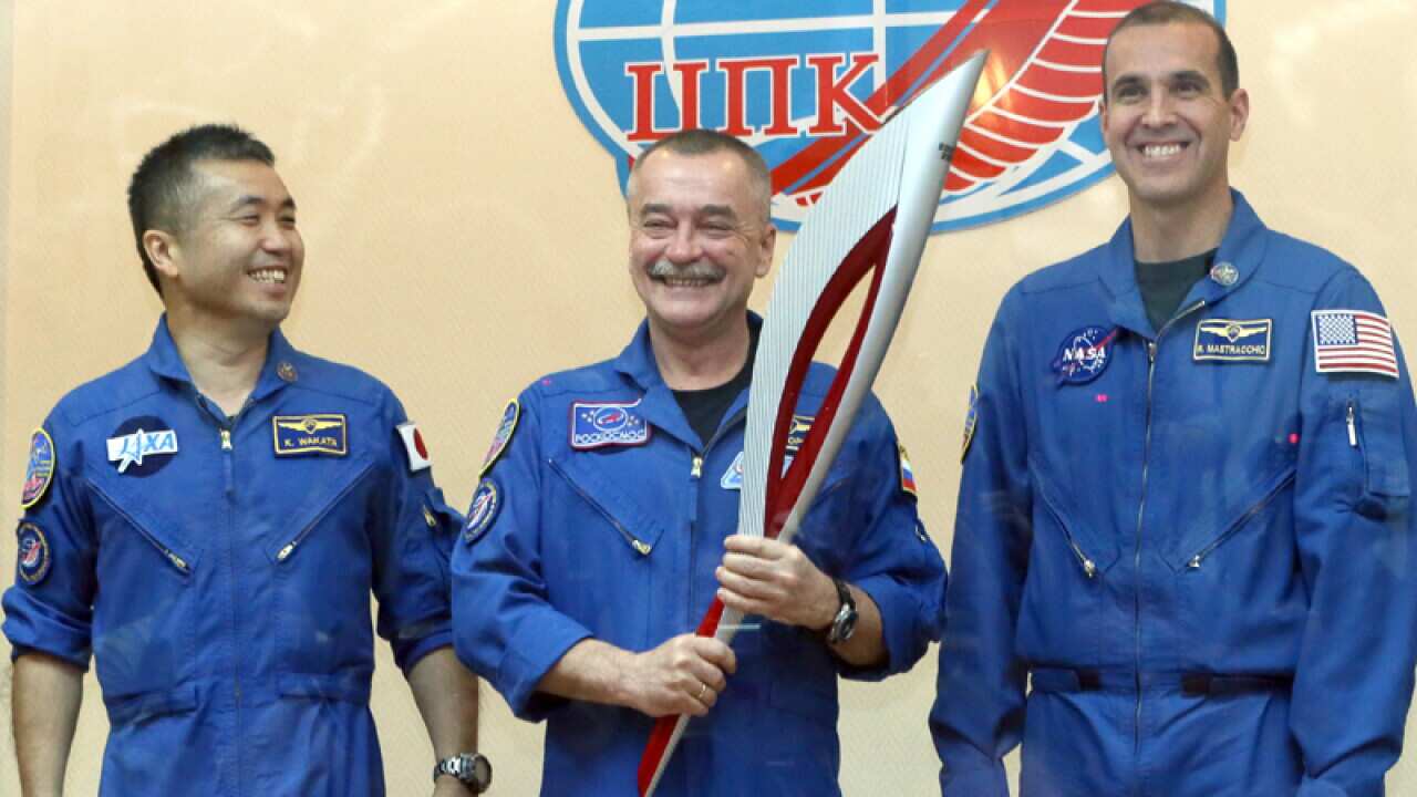 Three astronauts of the Soyuz spacecraft with the Sochi Olympic torch