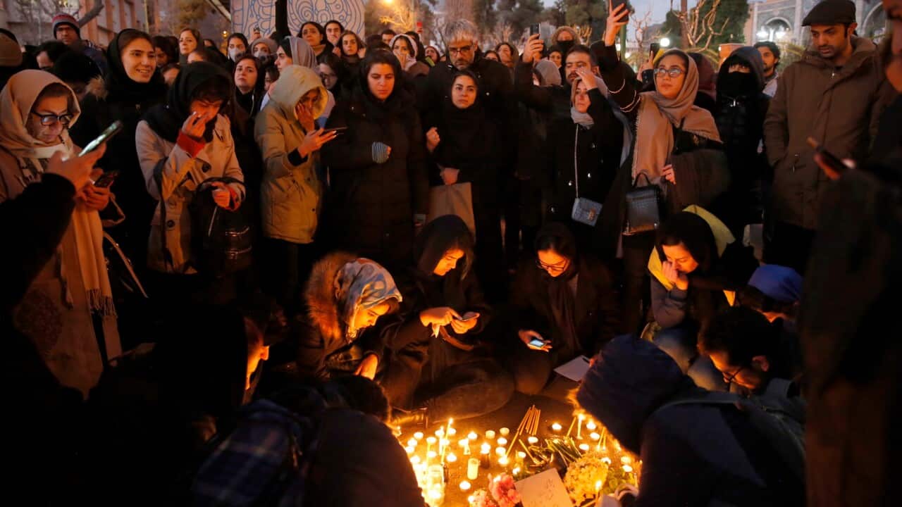 Iranians light candles for plane crash victims during a protest in front of the Amir Kabir University in Tehran