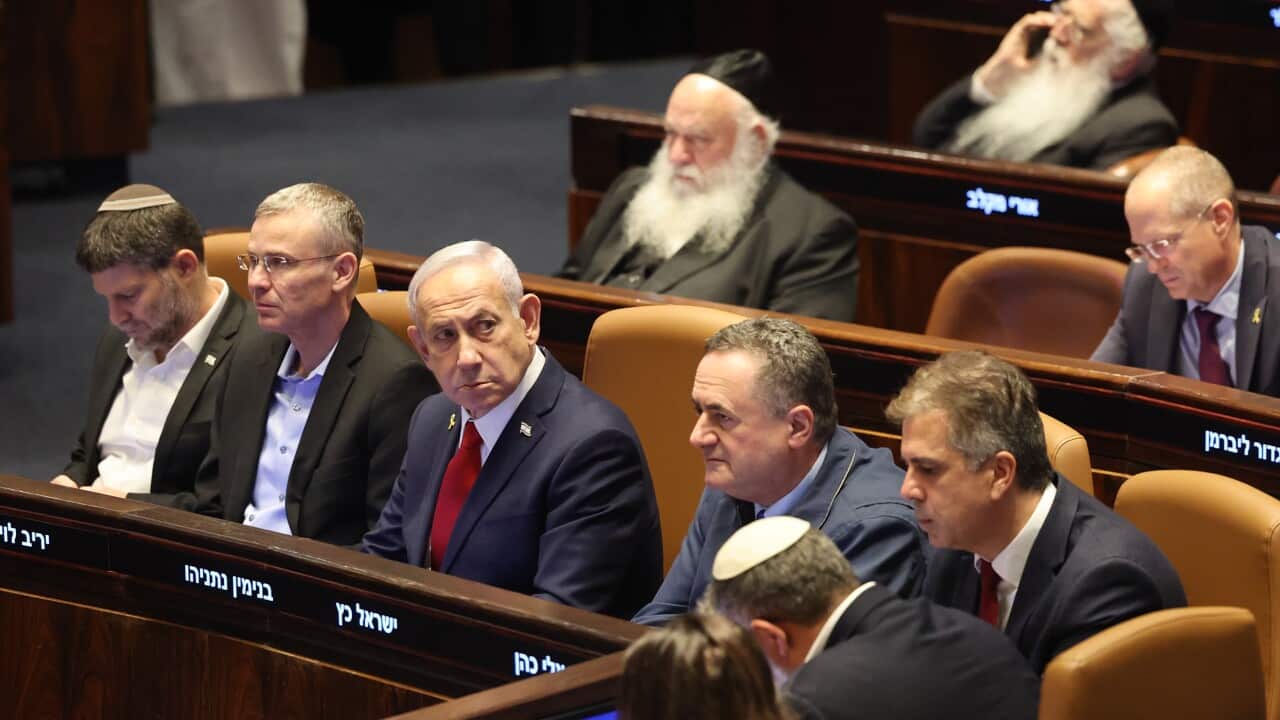 A group of men in suits sitting in chairs in a parliamentary chamber