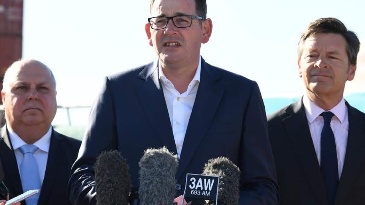 Daniel Andrews (centre) reacts during an address to media.