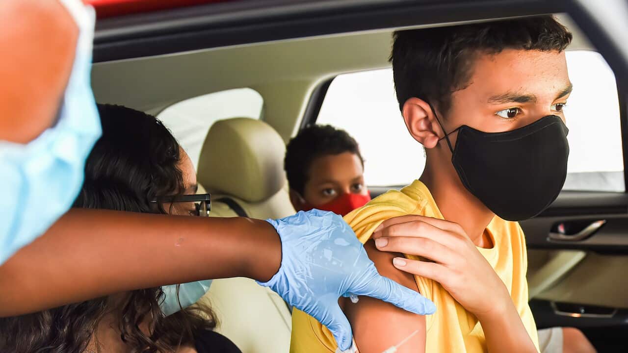 A nurse administers a COVID-19 vaccine to a kid at a drive-thru COVID-19 testing and vaccination site at Barnett Park in Orlando