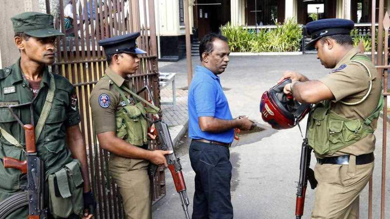 Sri Lankan Security personnel check people before they enter the church as services resume again after the Easter Sunday attacks,
