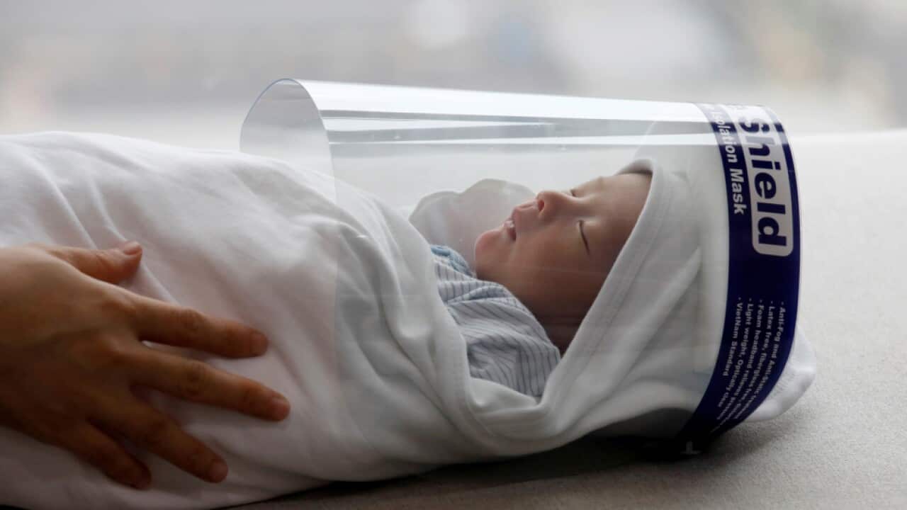 Newborn baby wearing a protective face shield in the time of COVID-19