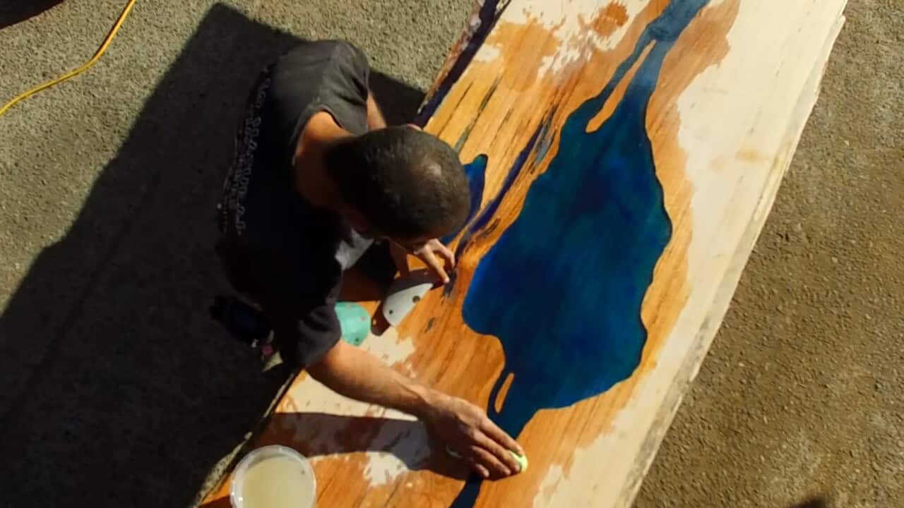 Goran, a Go Natural Timbers staff adds a blue resin to a slab.