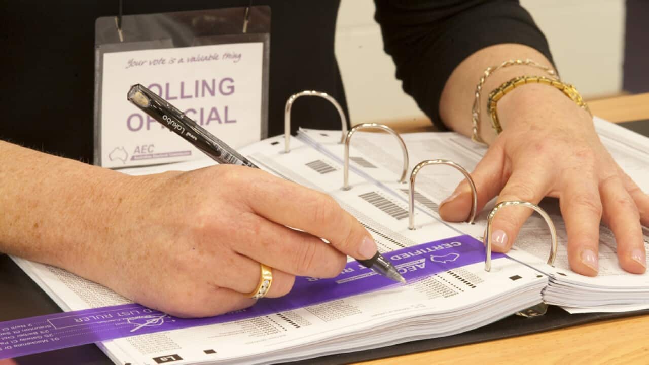 A polling official marks off a voter on the official electoral roll