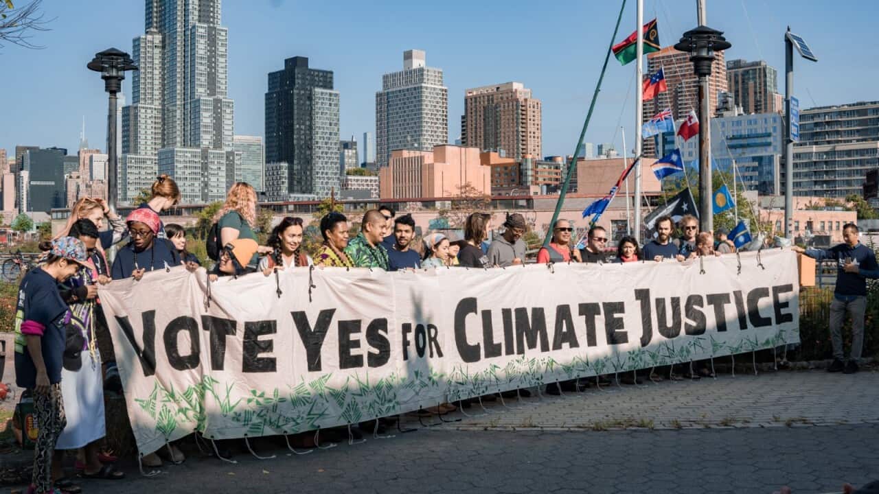 Youth campaigners holding a banner that reads "Vote Yes for Climate Justice" marching for climate action in New York.