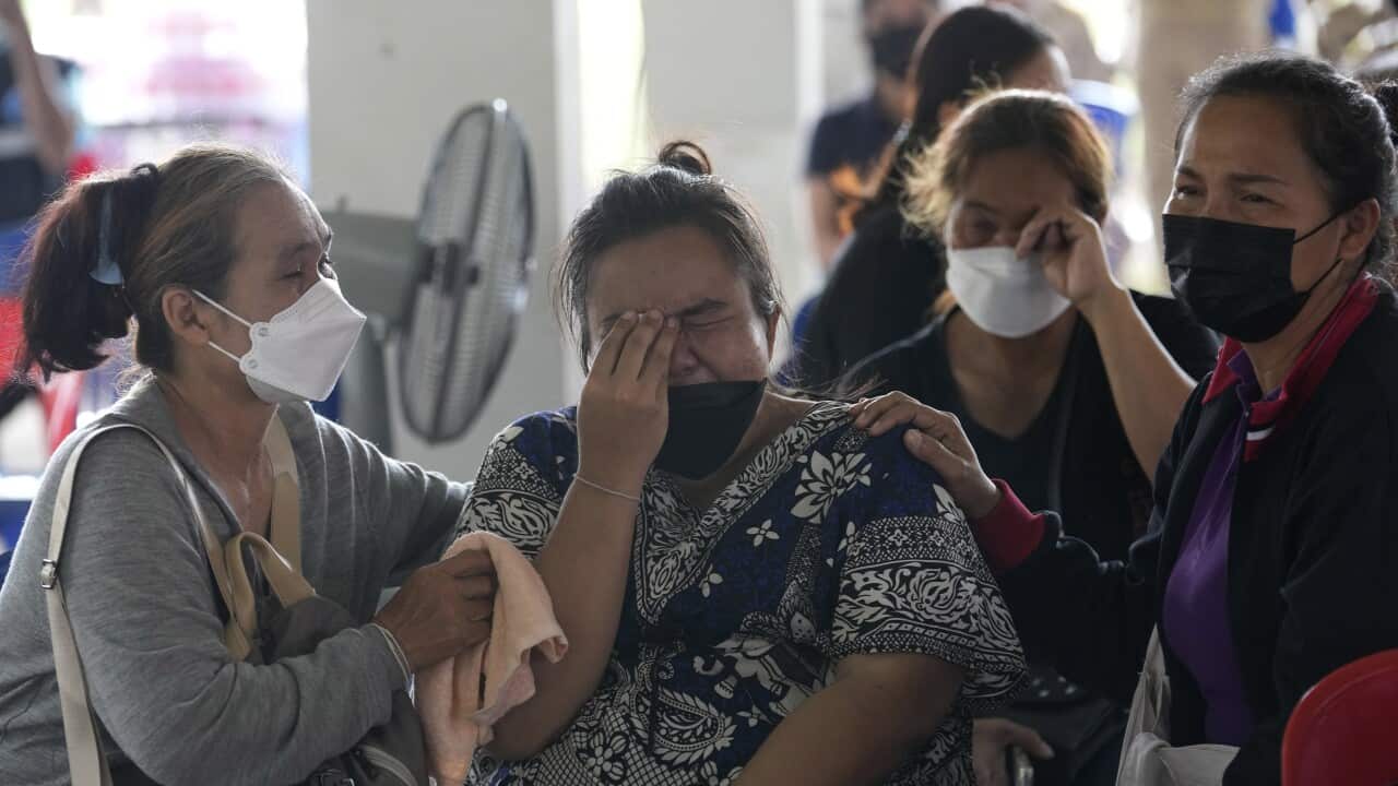 Four Thai women in face masks, crying