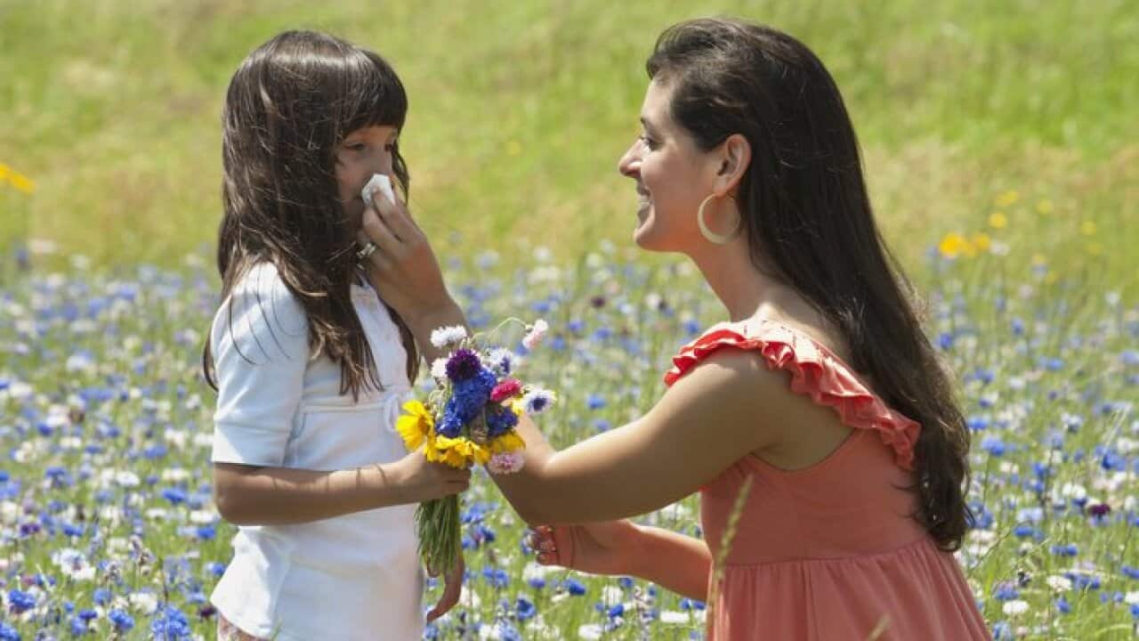 Mother wiping daughter's nose