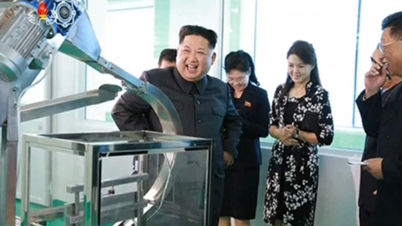 Kim Jong-un is impressed by a machine at a cosmetics factory in Pyongyang, as his wife watches on.  