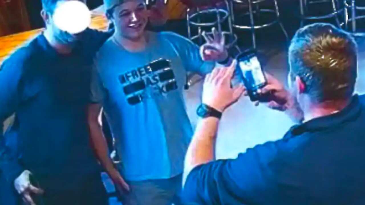 Kyle Rittenhouse (centre) is seen flashing the 'OK' hand gesture