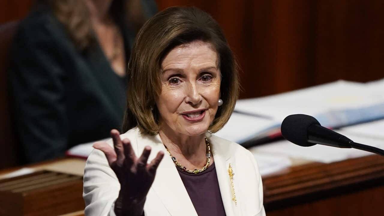 A woman in a white blazer speaks at a lecturn