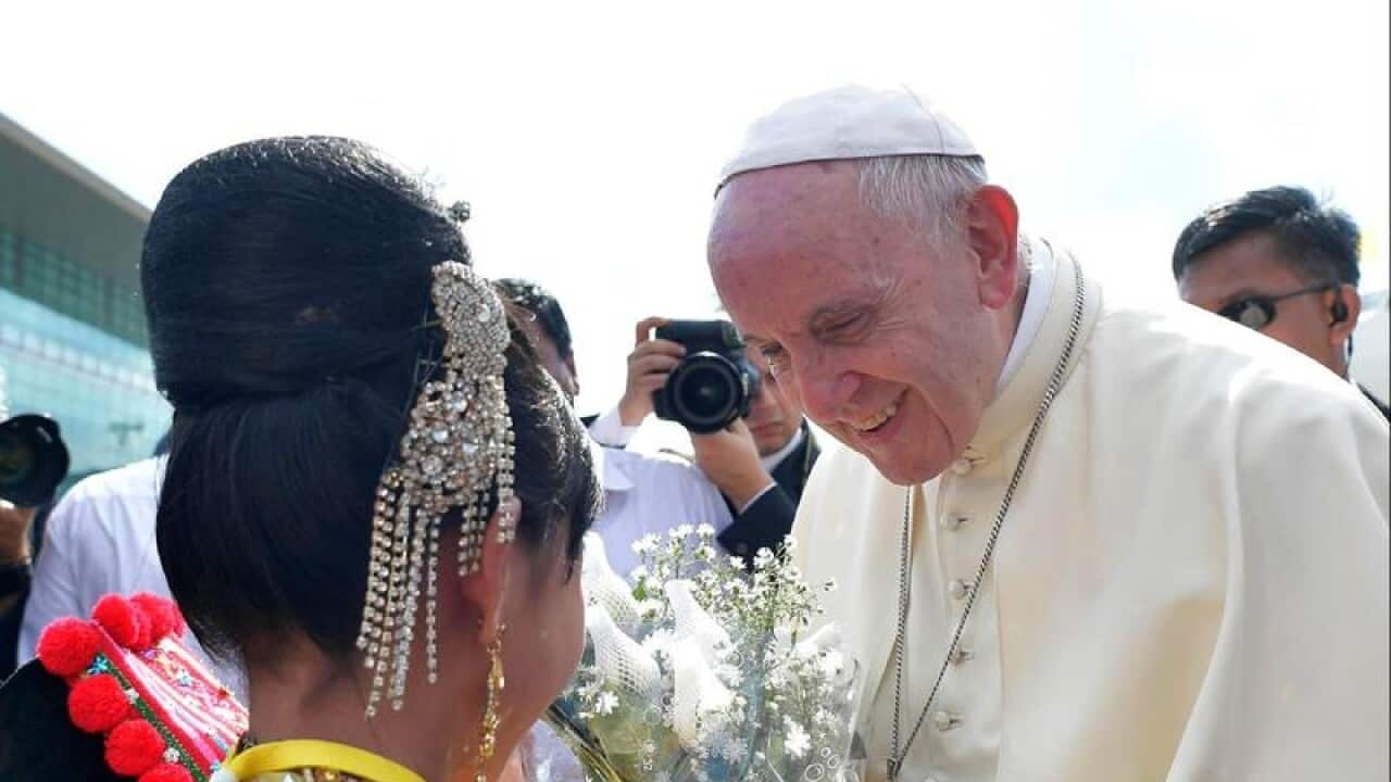 Pope Francis is welcomed upon his arrival at the airport in Yangon