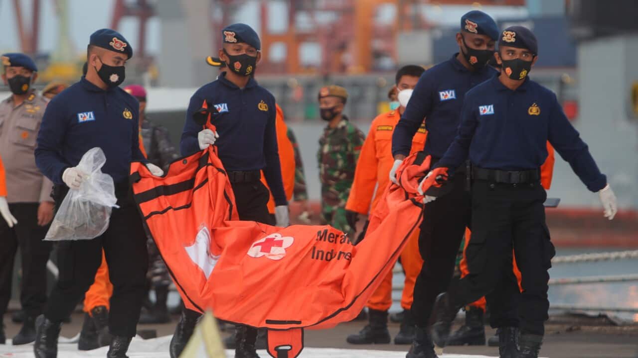 Members of the investigation team carry a body bag at Tanjung Priok port in Jakarta, Indonesia.
