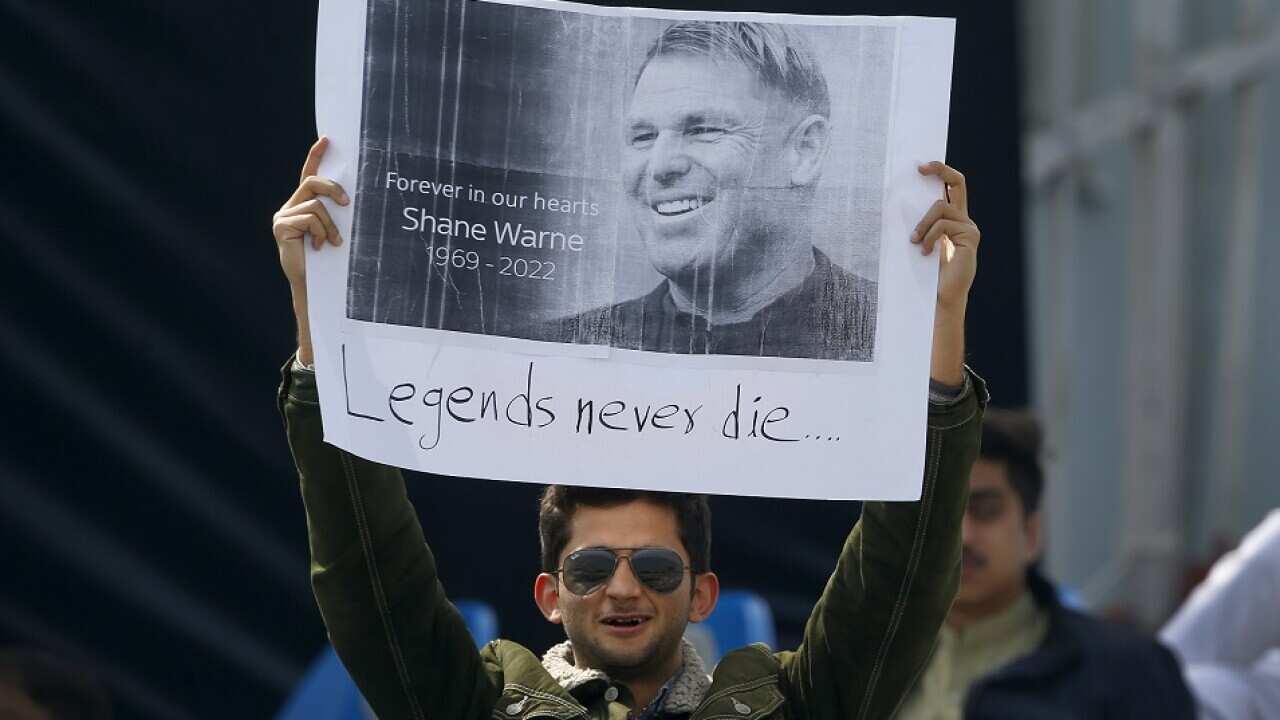 A cricket fan holds placard with the picture of Australian cricketer Shane Warne to pay tribute