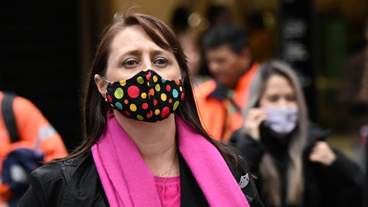 Woman wears a multi-coloured face mask