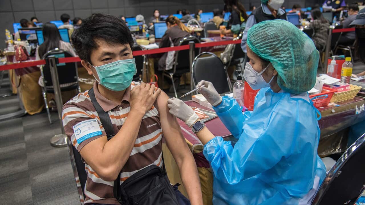 A health worker administers a dose of COVID-19 vaccine to a man in Nonthaburi.Thailand.