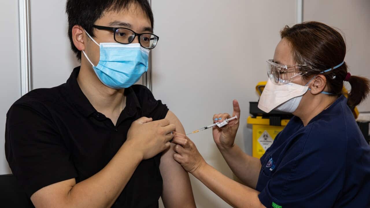 A health worker administers the third dose COVID-19 vaccine