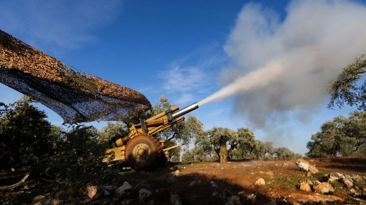 Turkish backed rebel fighters fire a howitzer toward Syrian government's forces positions near the village of Neirab in Idlib province, Syria.
