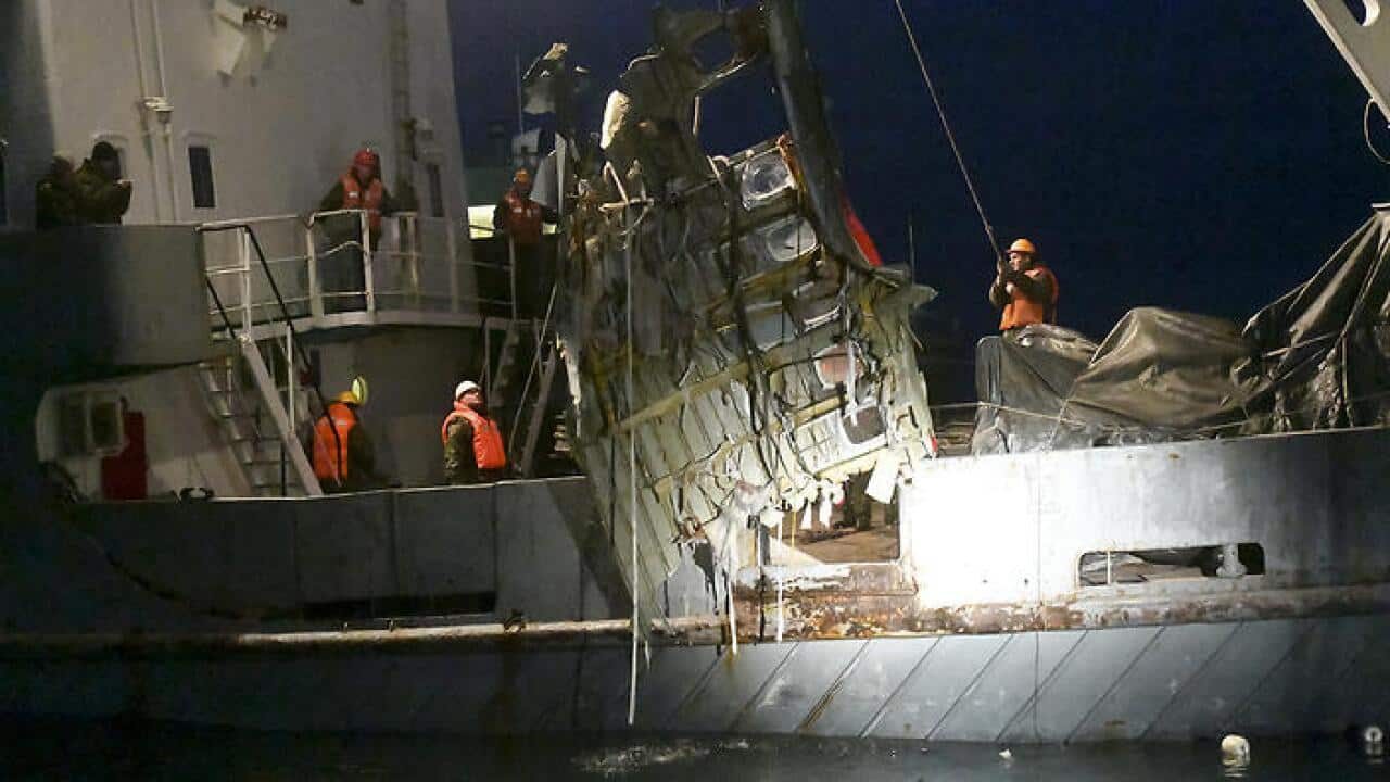 Ministry employees lift a fragment of a plane in the Black Sea, outside Sochi, Russia.