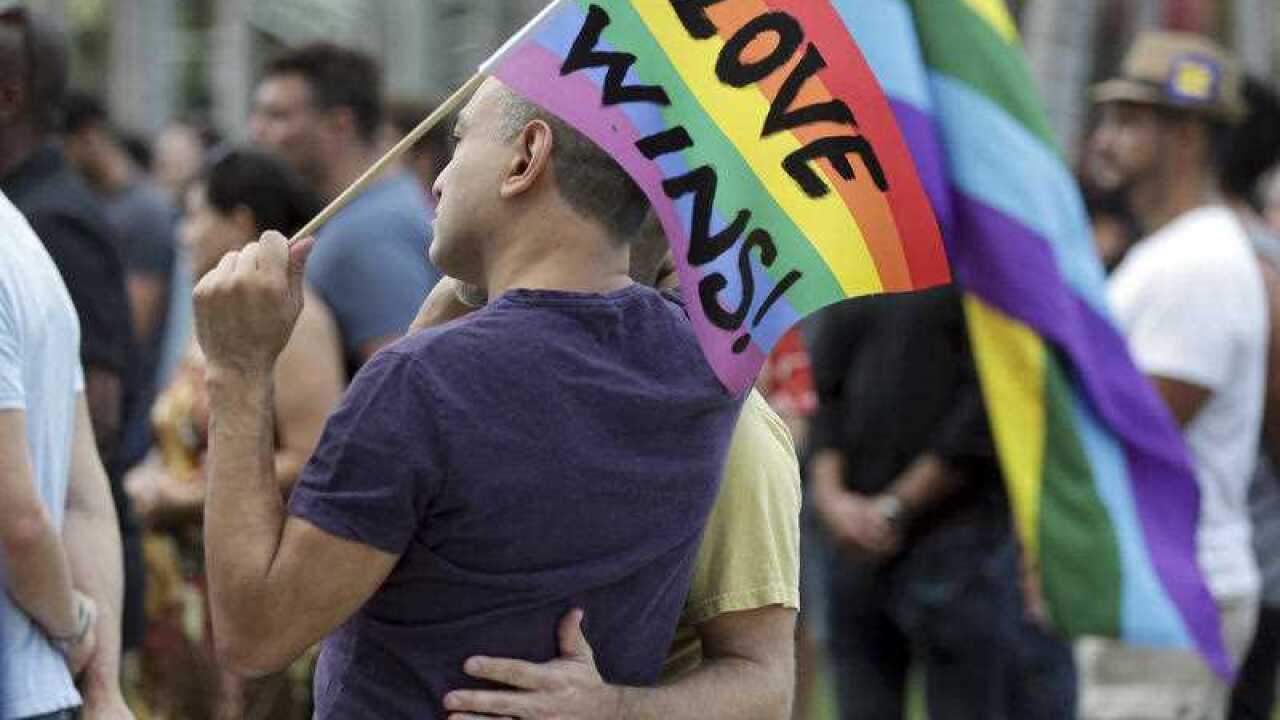 Juan Mantilla, 42, of Miami Beach, Florida, left, stands with his partner during a vigil in memory of the victims of the Orlando mass shooting.