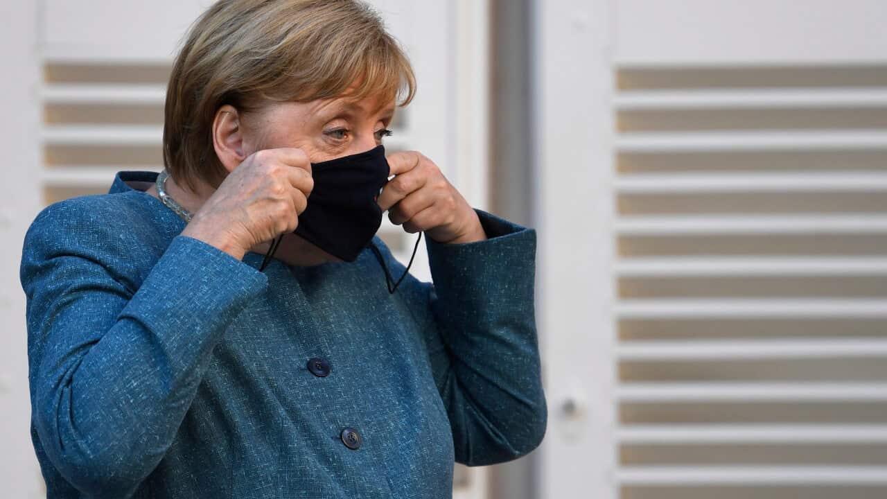 German Chancellor Angela Merkel takes her mask off