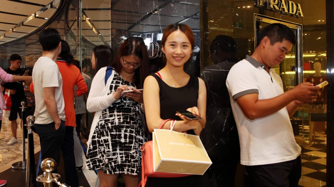 Shopper Chloe Huang waits in line for Prada to open