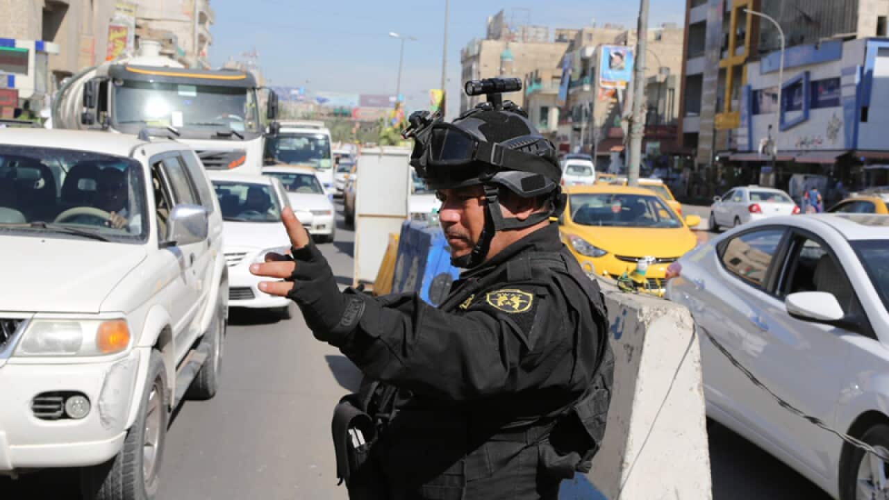 An Iraqi policeman stands guard at a checkpoint in Baghdad