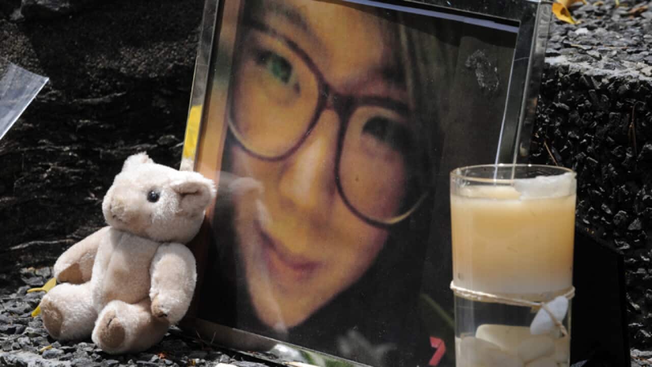 An image of South Korean woman Eunji Ban among flowers and tributes