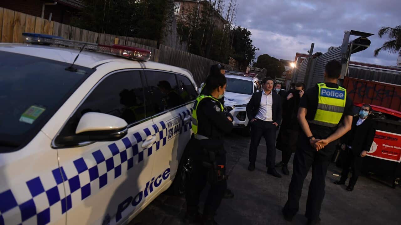 People speak with Victorian Police outside of a building near a Ripponlea synagogue in Melbourne, Tuesday, September 7, 2021. A building near a synagogue in Melbourne