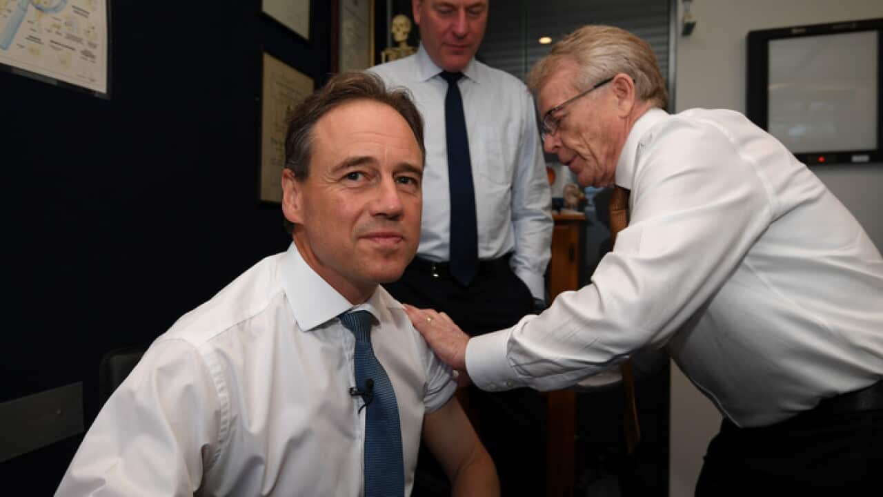 Federal Health Minister Greg Hunt receives a flu vaccine from Dr Brian Morton (AAP)