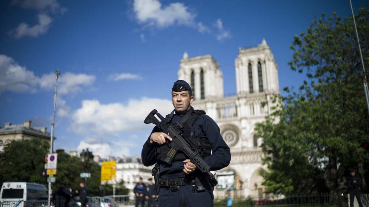 A French police officer stands guard outside of the Notre Dame cathedral in Paris