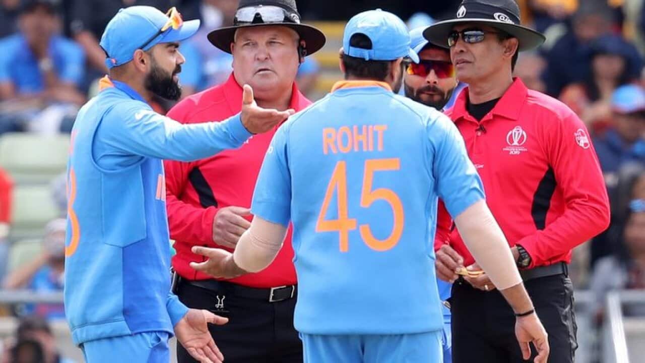 India's captain Virat Kohli, left, speaks with umpires after an unsuccessful review decision during the Cricket World Cup match between India and Bangladesh at Edgbaston in Birmingham, England, Tuesday, July 2, 2019. (AP Photo/Rui Vieira)