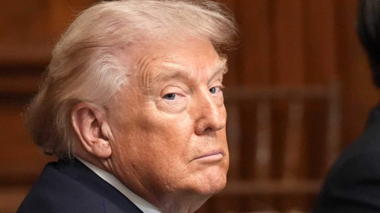 Donald Trump stares blankly over his right shoulder into the camera.