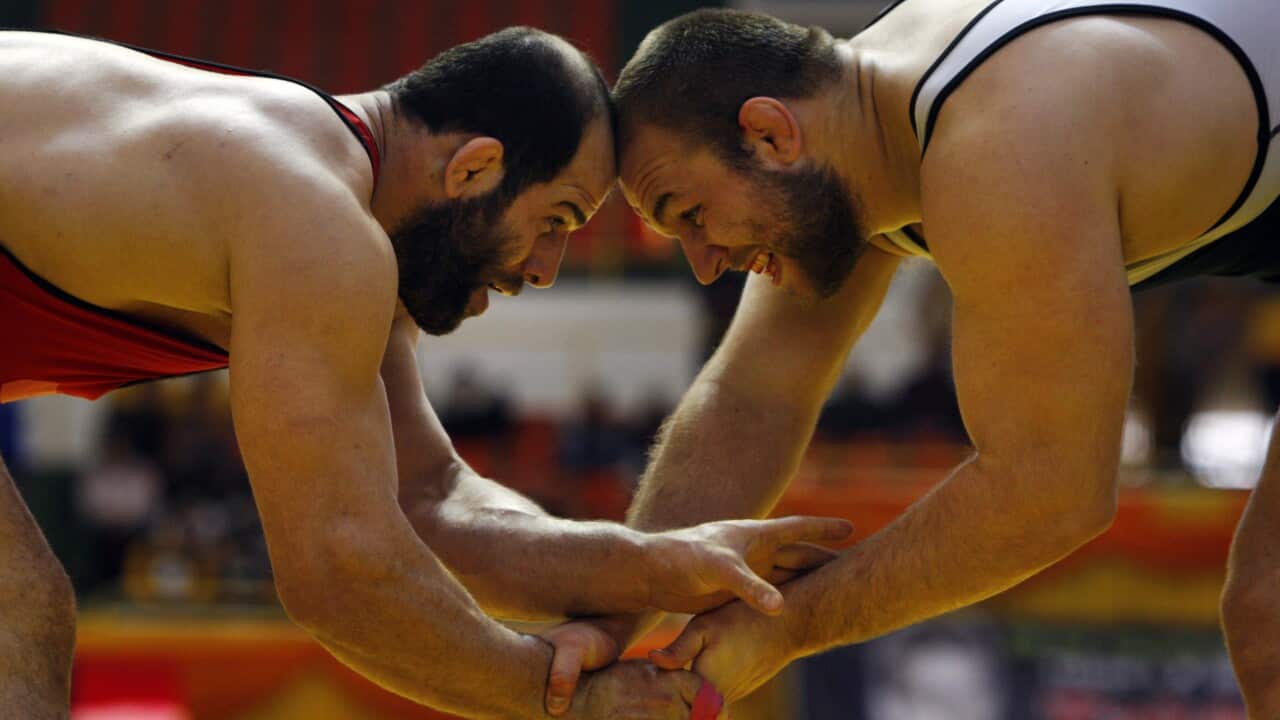 In this 2009 photo, Iran's free style wrestler Fardin Masoumi, left, and his U.S. competitor Tervel Dlagnev, fight during Iran's Takhti Wrestling Cup