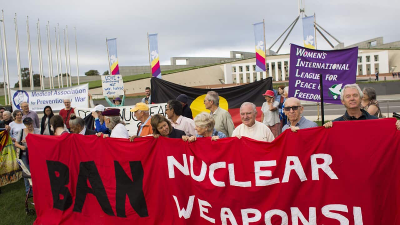 Protestors hold banners during a protest in Canberra