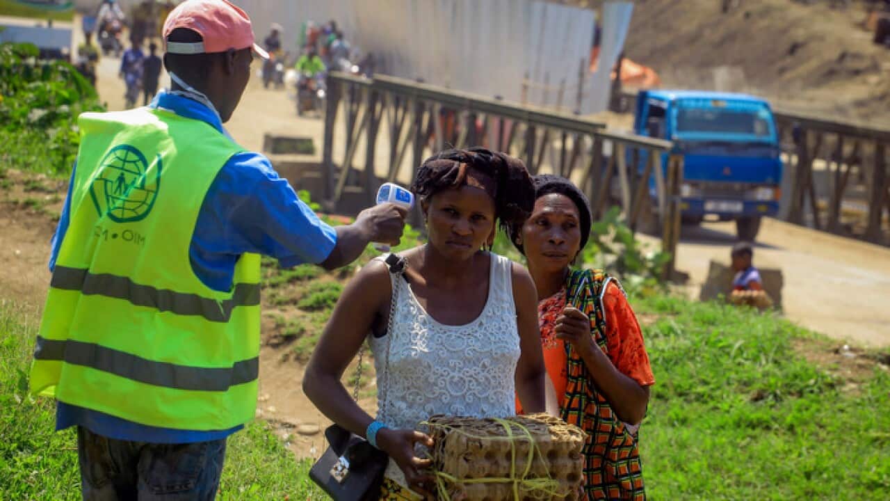 People are checked for symptoms of Ebola at the border crossing near Kasindi, eastern DRC