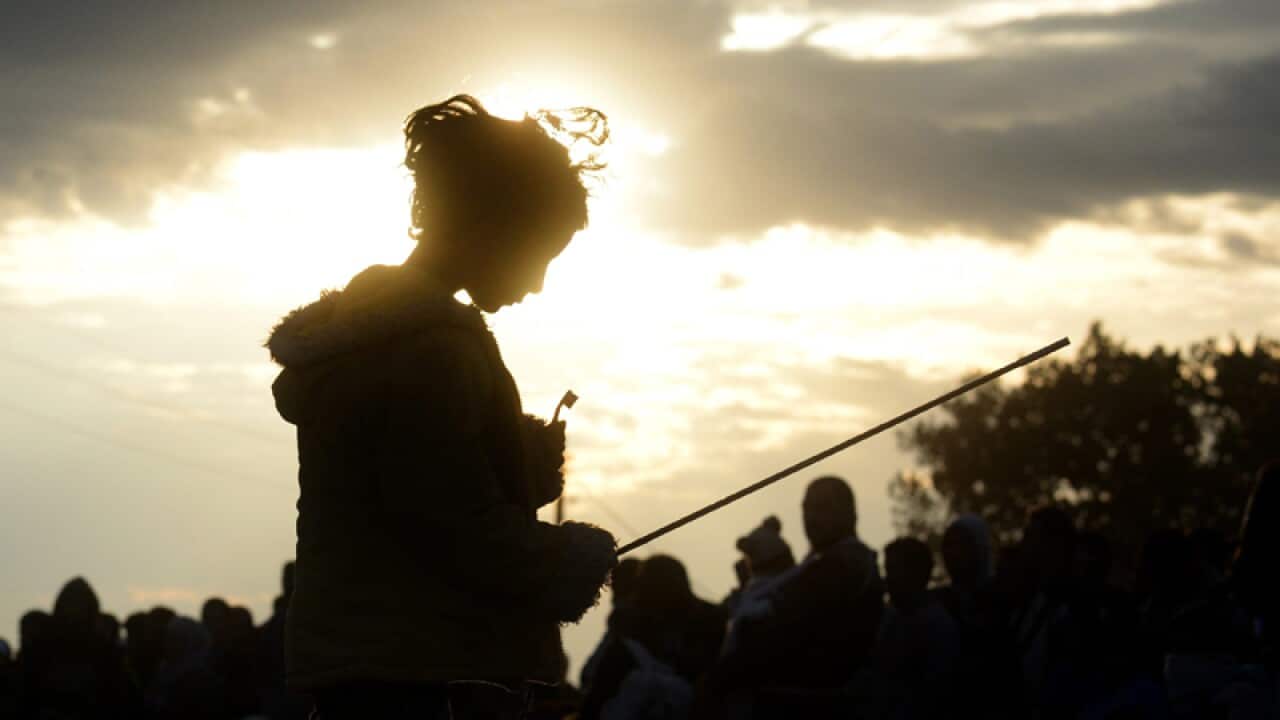 A migrant girl waits for a permission to enter new refugee camp