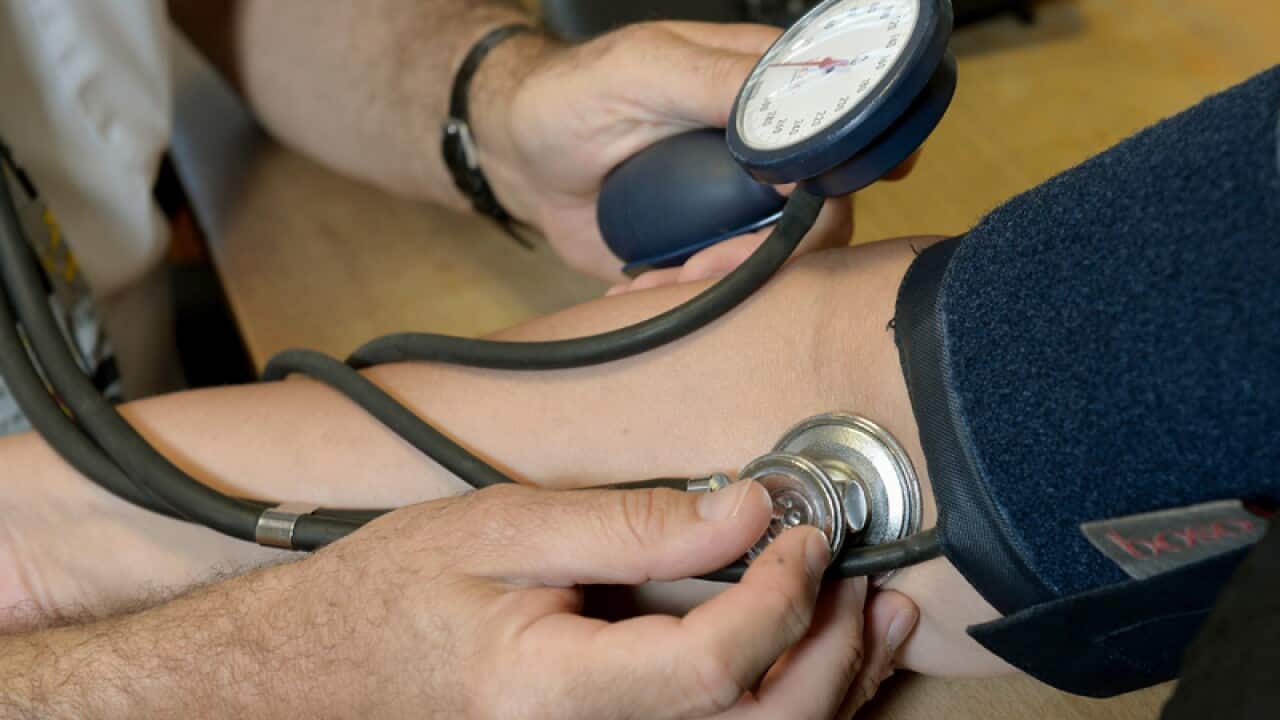 A doctor checks a patient's blood pressure.