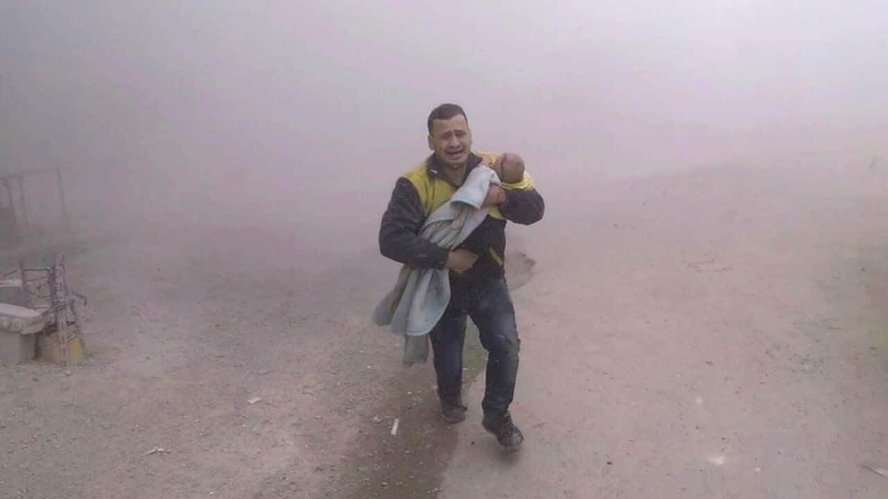 A White Helme paramedic carrying his wounded son as they flee from the scene of an attack near Damascus.
