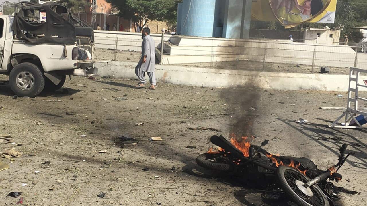 Pakistani security officials inspect the scene of a suicide bomb blast