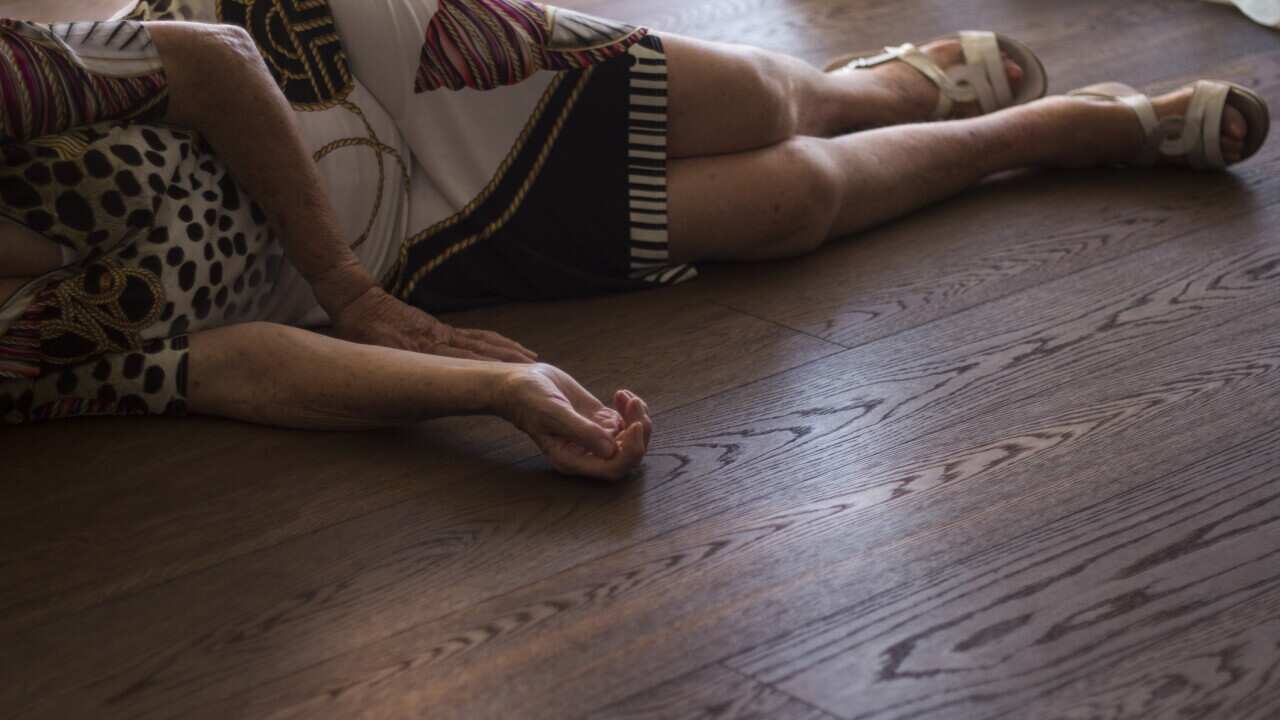 Elderly woman lying on floor after fall