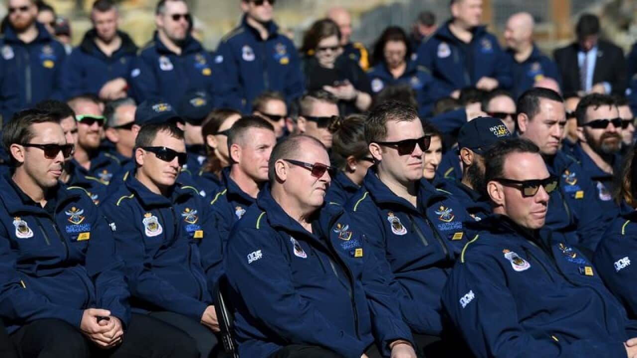 Australian athletes listen on as Defence Minister Marise Payne speaks.