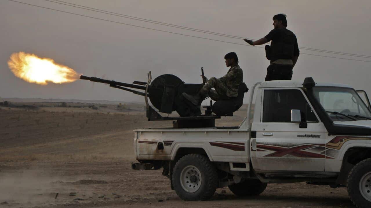 Turkish-backed Syrian fighters fire a truck mounted heavy gun near Manbij, on October 14, 2019,