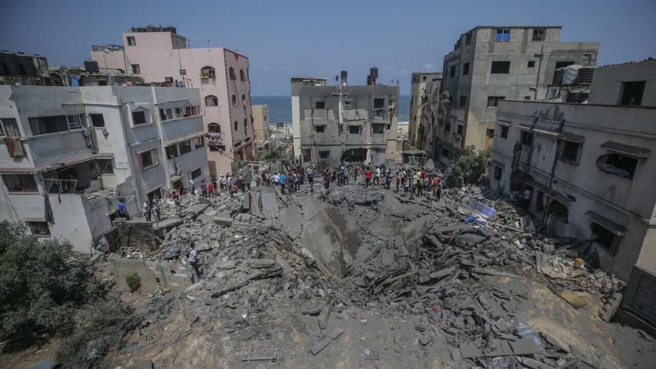 People inspect a destroyed building.