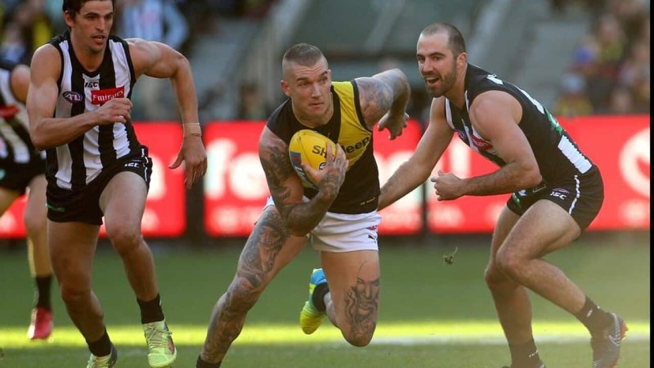 Dustin Martin of the Tigers (centre) breaks away.