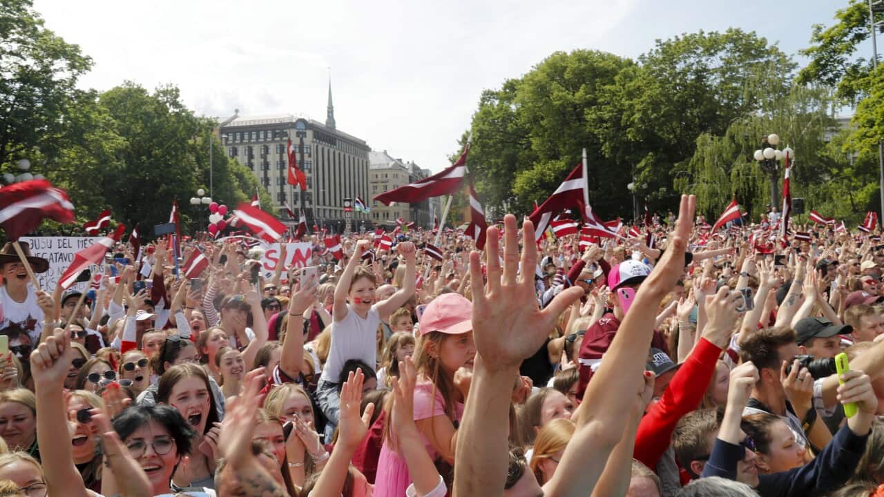 People with Latvian flag celebrate.