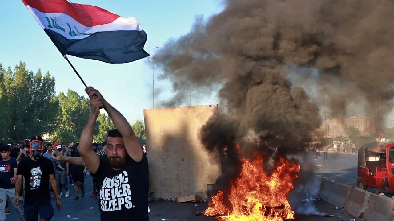 Anti-government protesters set fires and close a street during a demonstration in Baghdad.